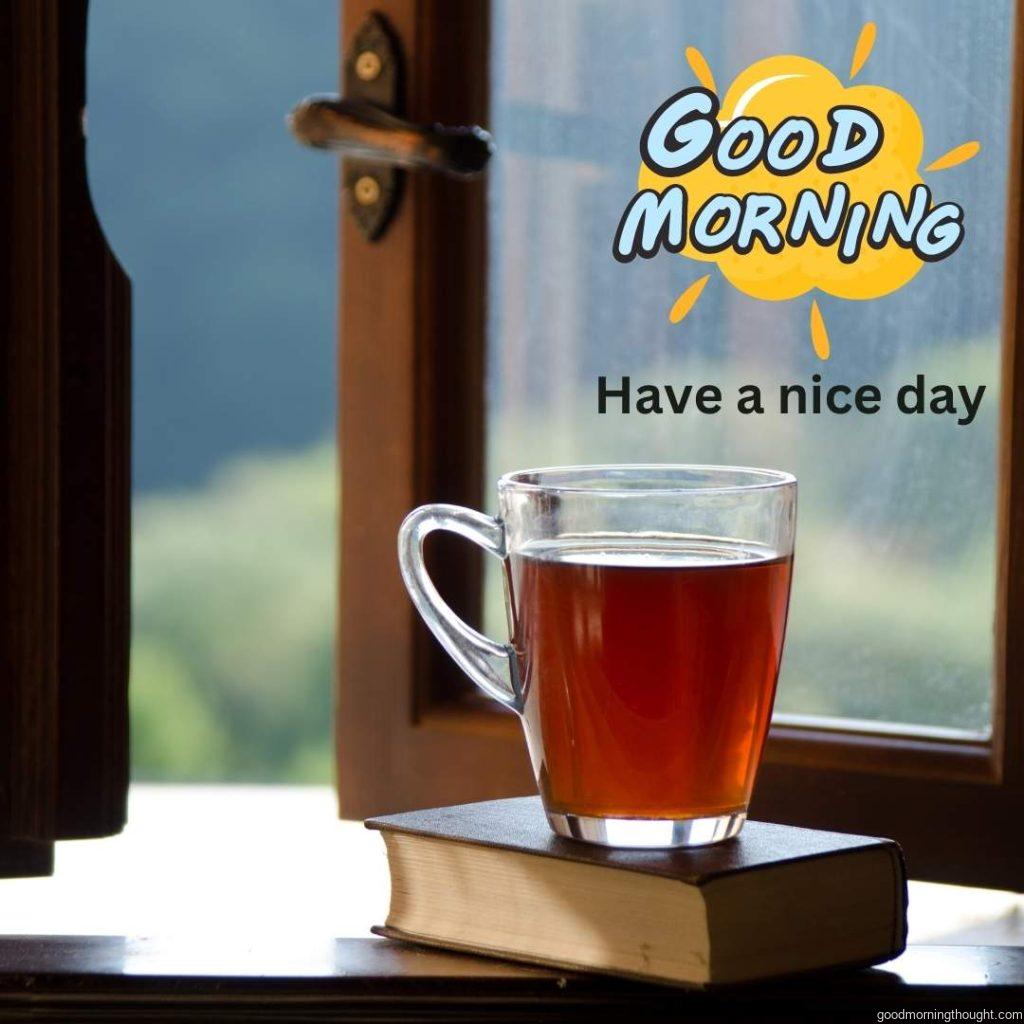 Cup of black tea and book on window sill