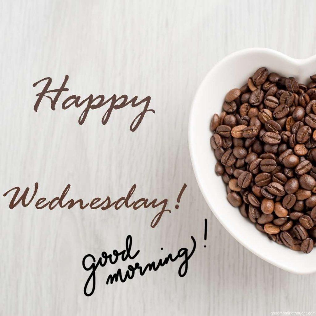 Good Morning happy Wednesday note with coffee beans in bowel on wooden background