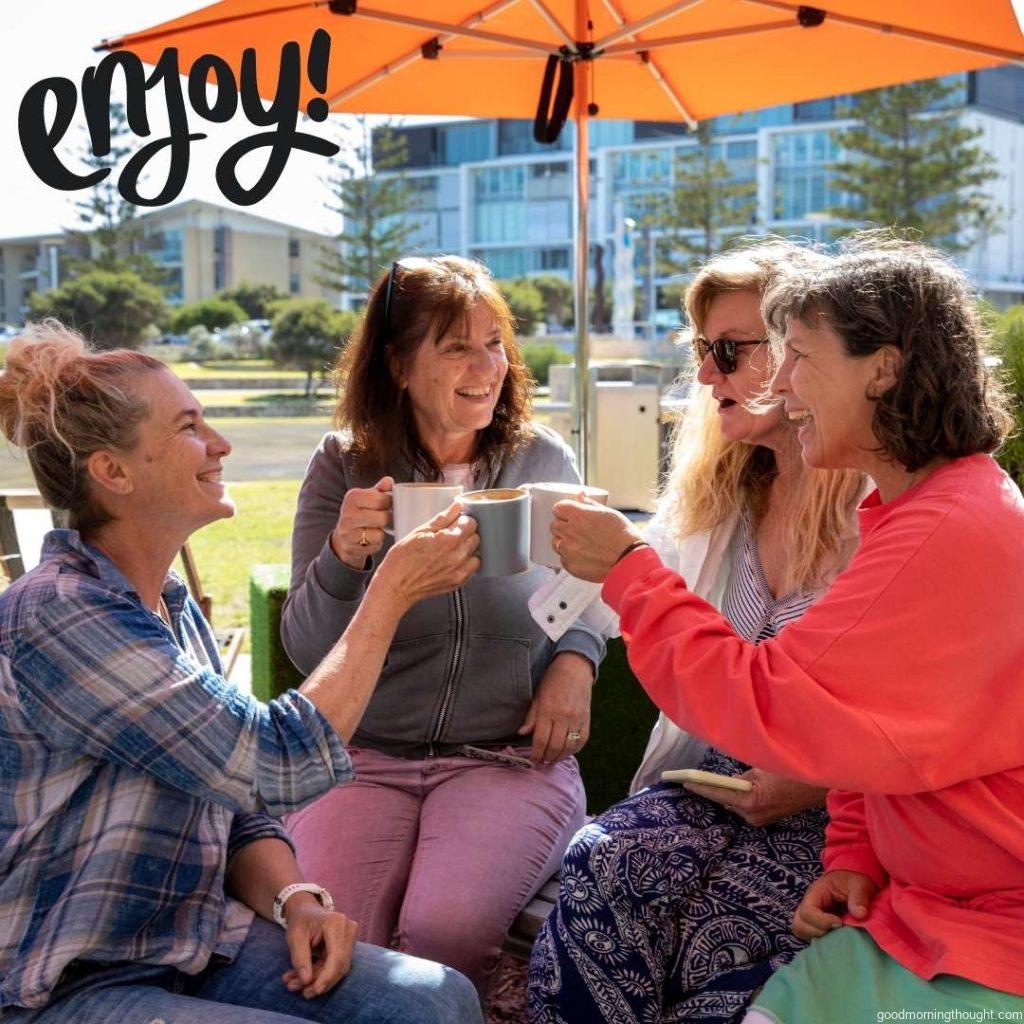 Group of caucasian matured women sitting outdoor in cafe and enjoying coffee