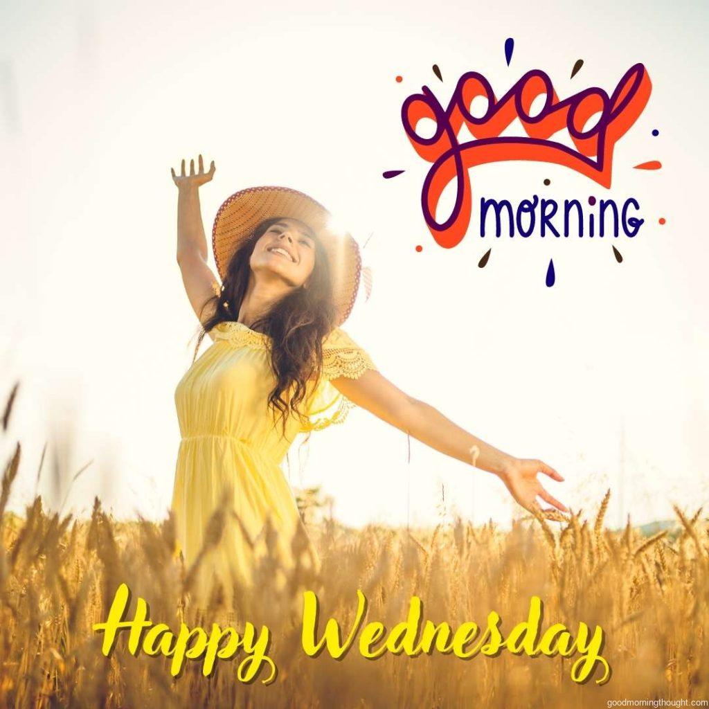 Happy young girl with a open arms in the wheat field enjoying beautiful Wednesday Morning