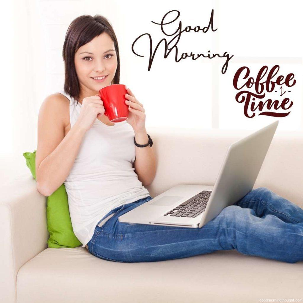 Young Caucasian women sitting on sofa with her laptop and drinking morning coffee