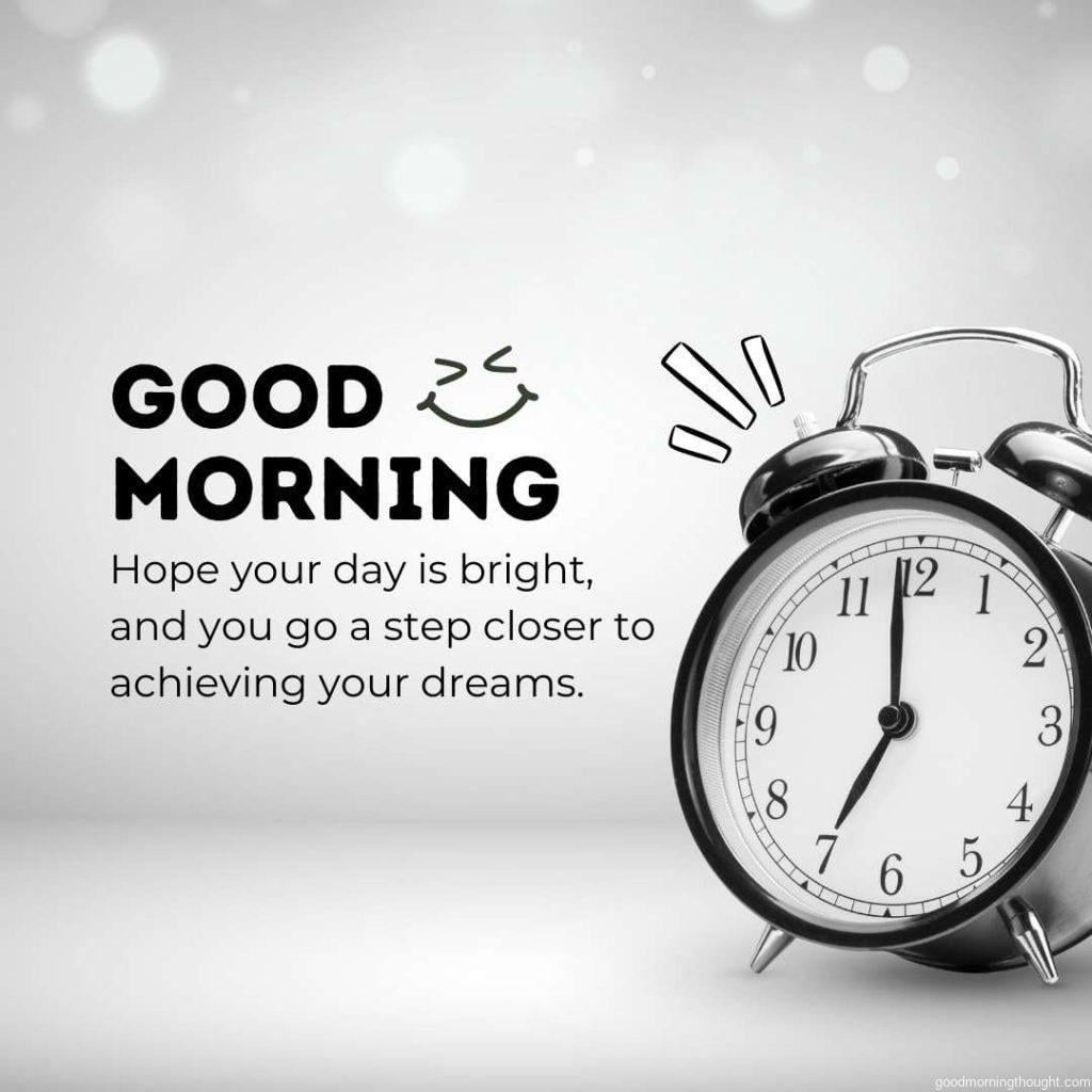 Alarm clock on gray background with good morning text message written on it