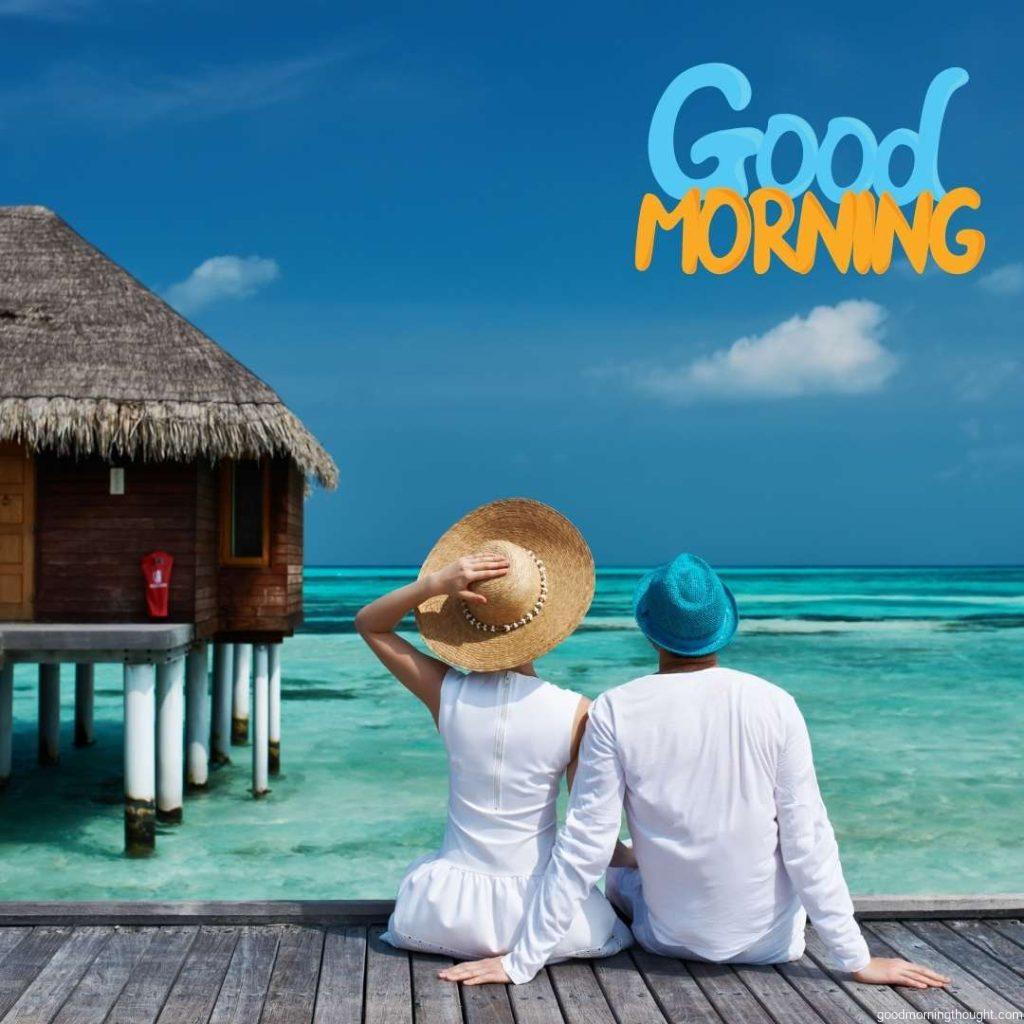 A couple on a beach jetty in the Maldives in the morning