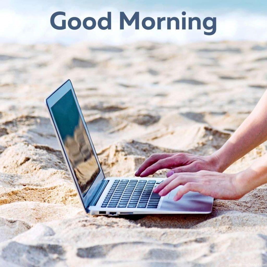 Asian businessman using laptop on the beach in the morning