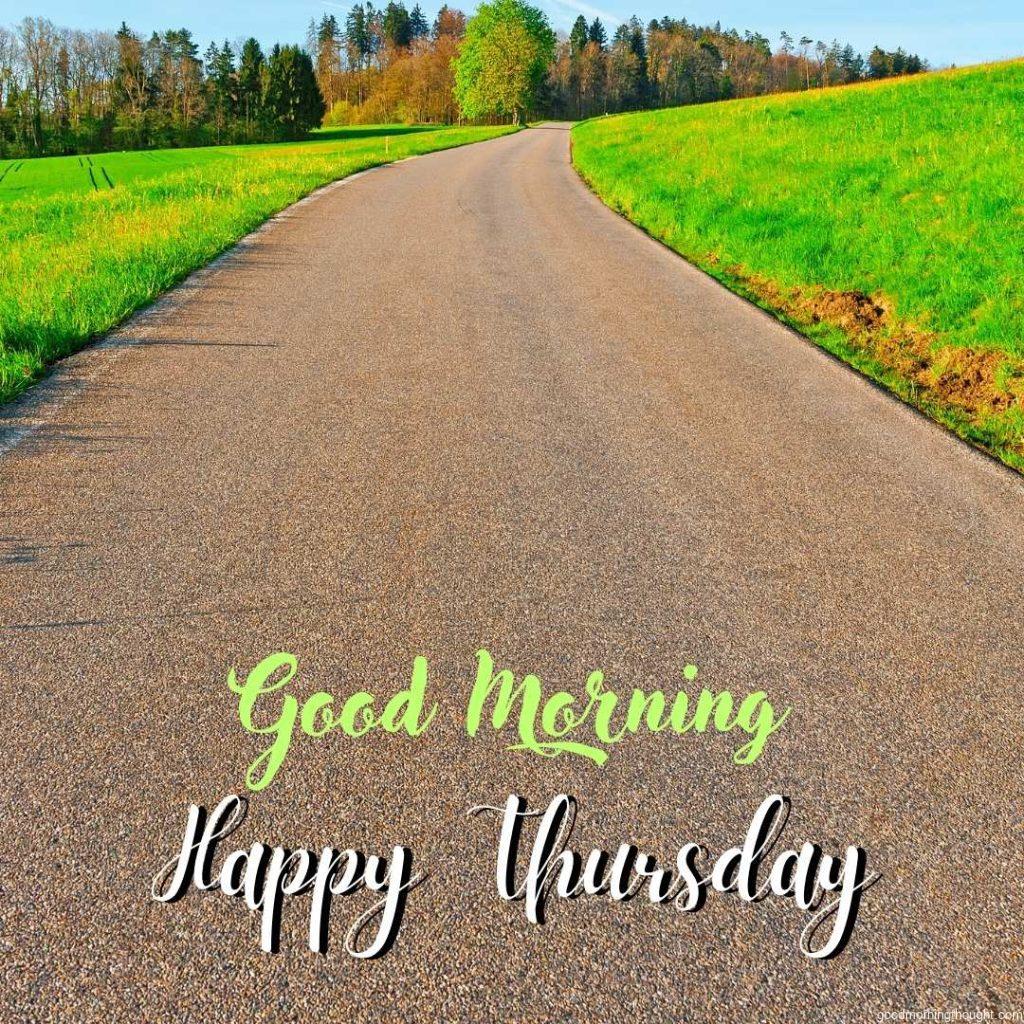 Asphalt road leading to the farmhouse in the Swiss Alps in the early morning and _Good Morning, Happy Thursday_ text