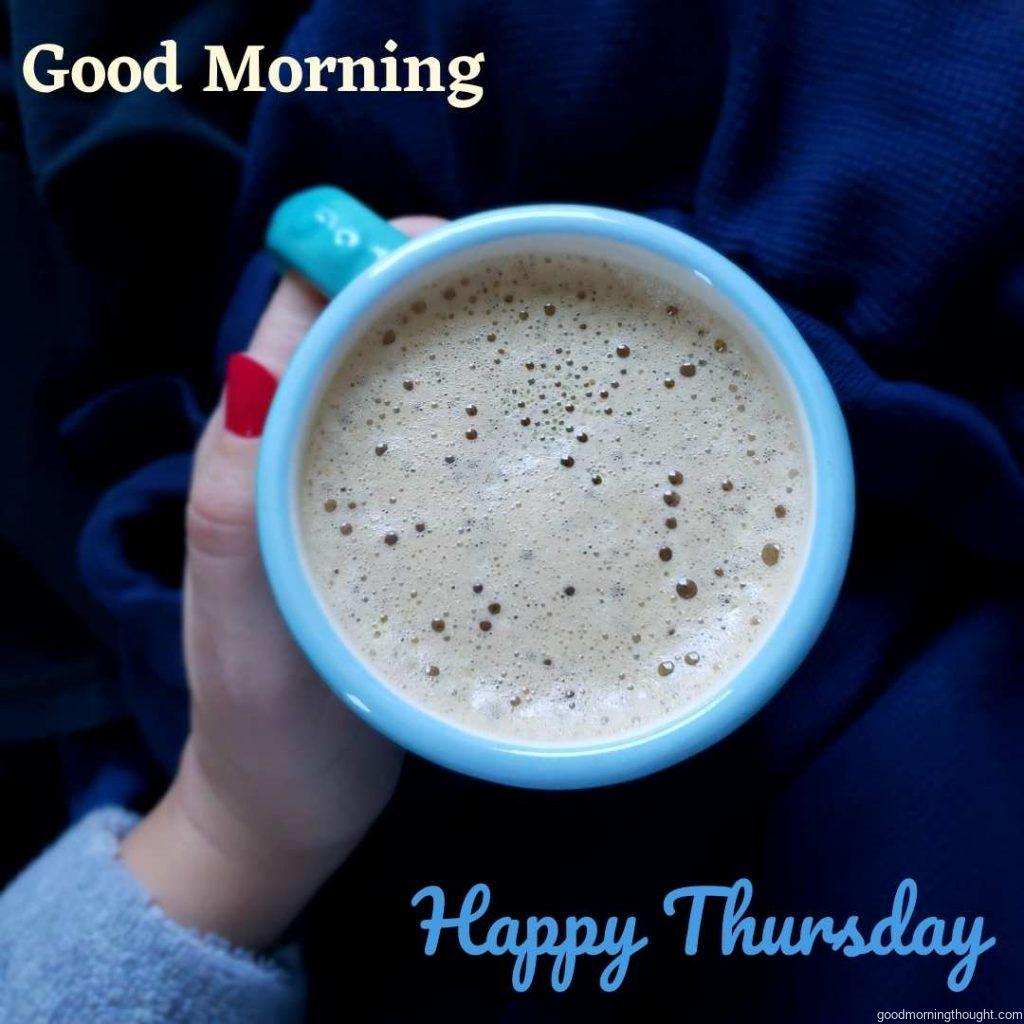 Close-up view of Sky Blue Coffee cup holding a dark blue background on which _Good Morning, Happy Thursday_ text