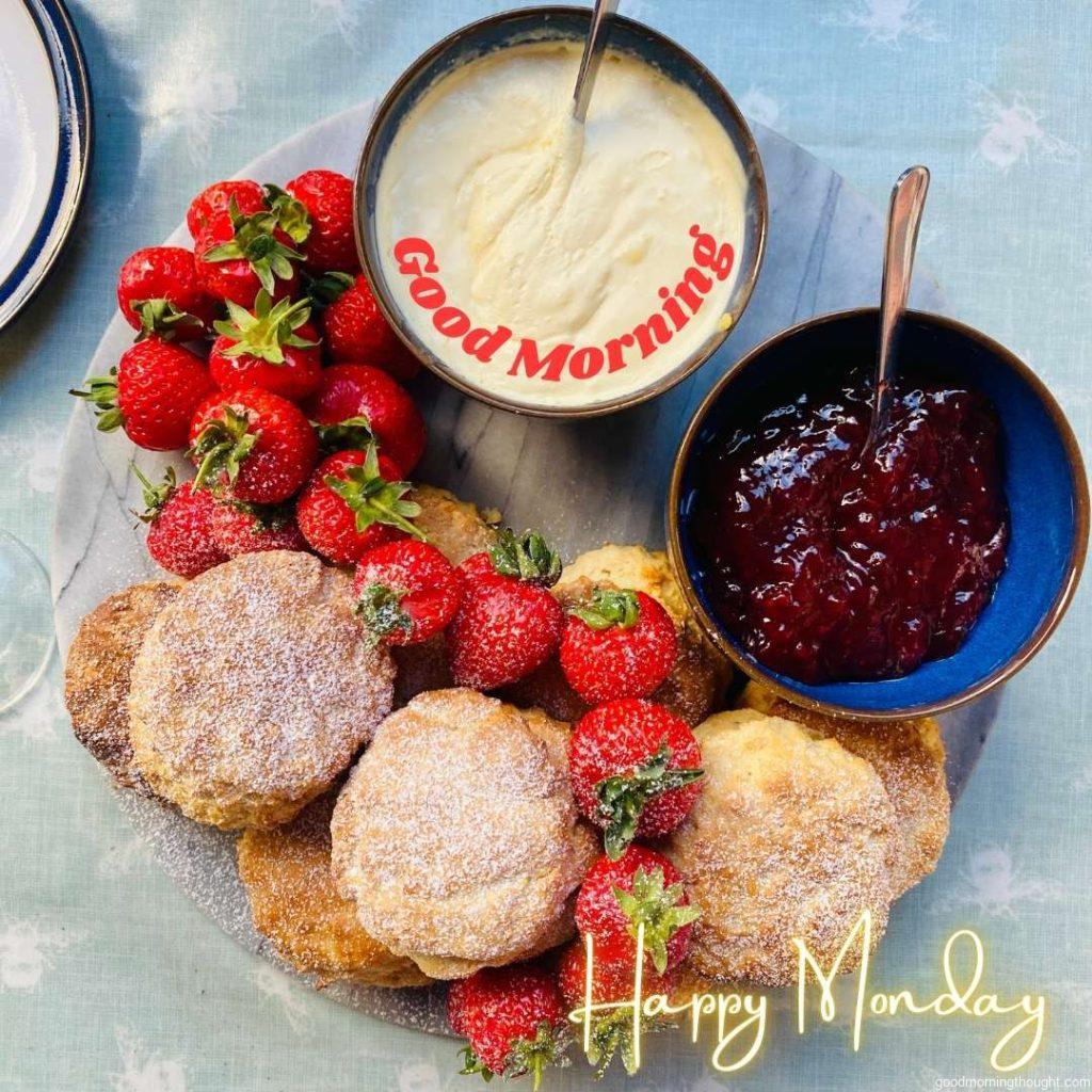 Scones, strawberries, and cream with _Good morning, happy Monday_ text