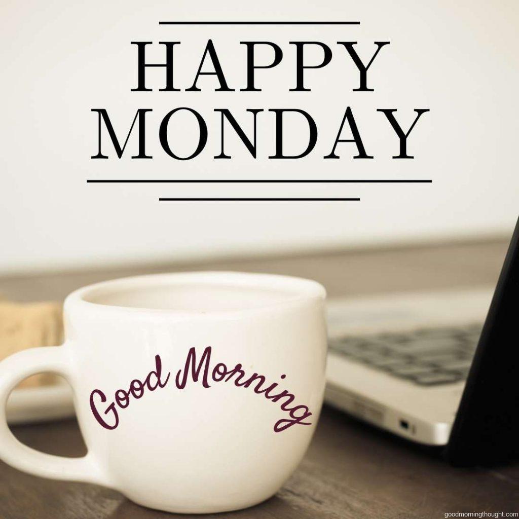 laptop and cup of hot coffee on the table in the background, on which _Good morning, happy Monday_ text is written