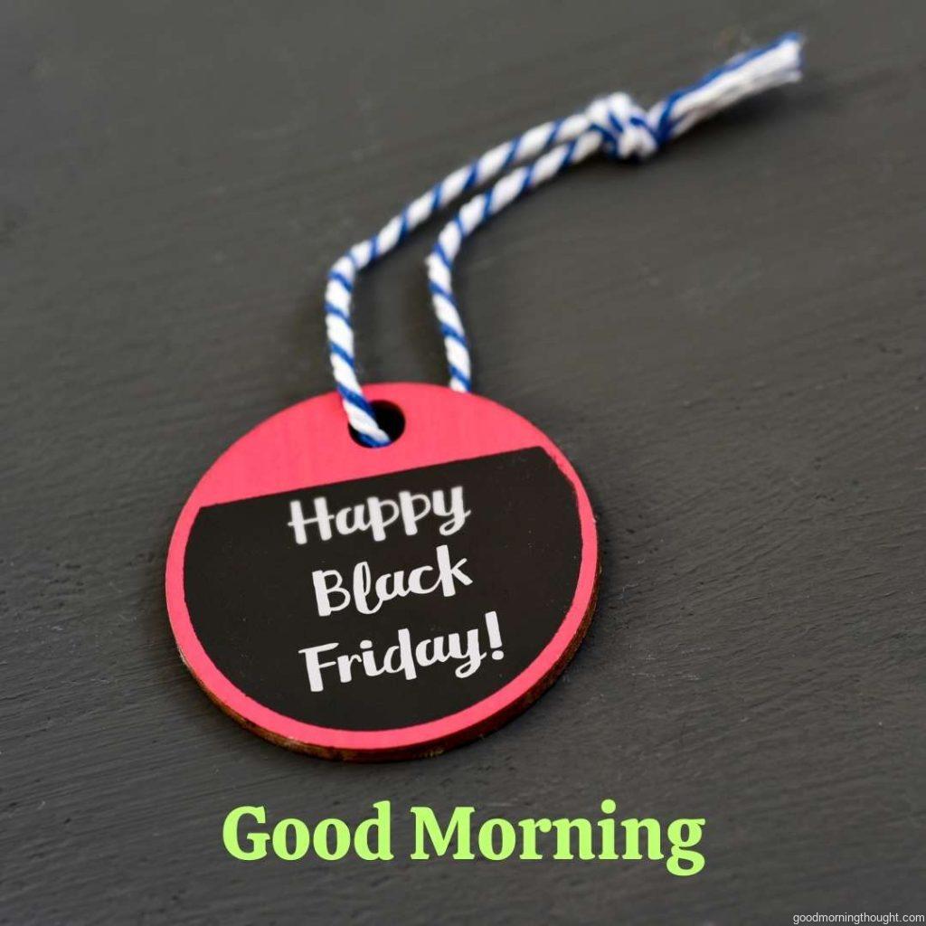 text _Happy Black Friday_ written in white on a red and black paper label with a blue and white string attached to it, against a dark grey background