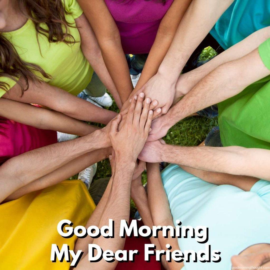 A high view of a team of friends showing unity with their hands together, Good morning text