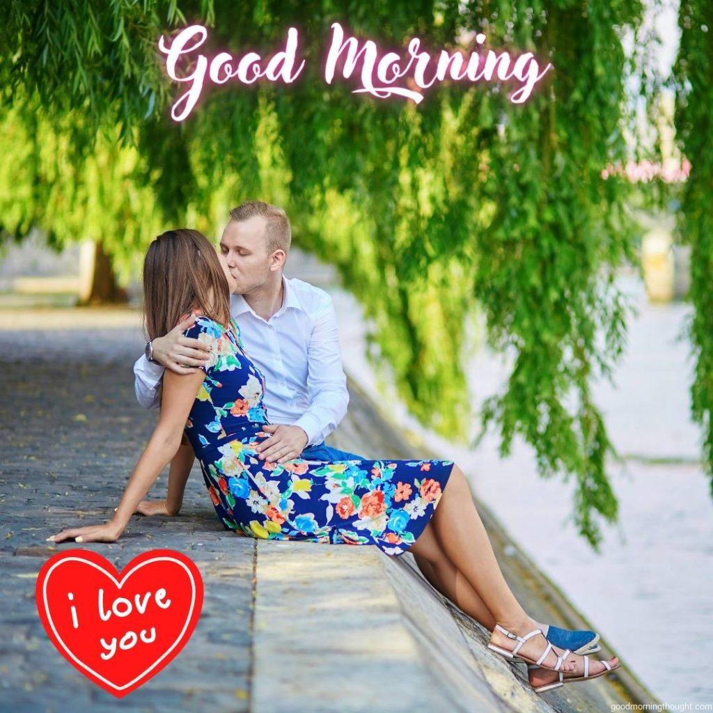 A romantic couple sits on the Seine embankment in Paris in the morning