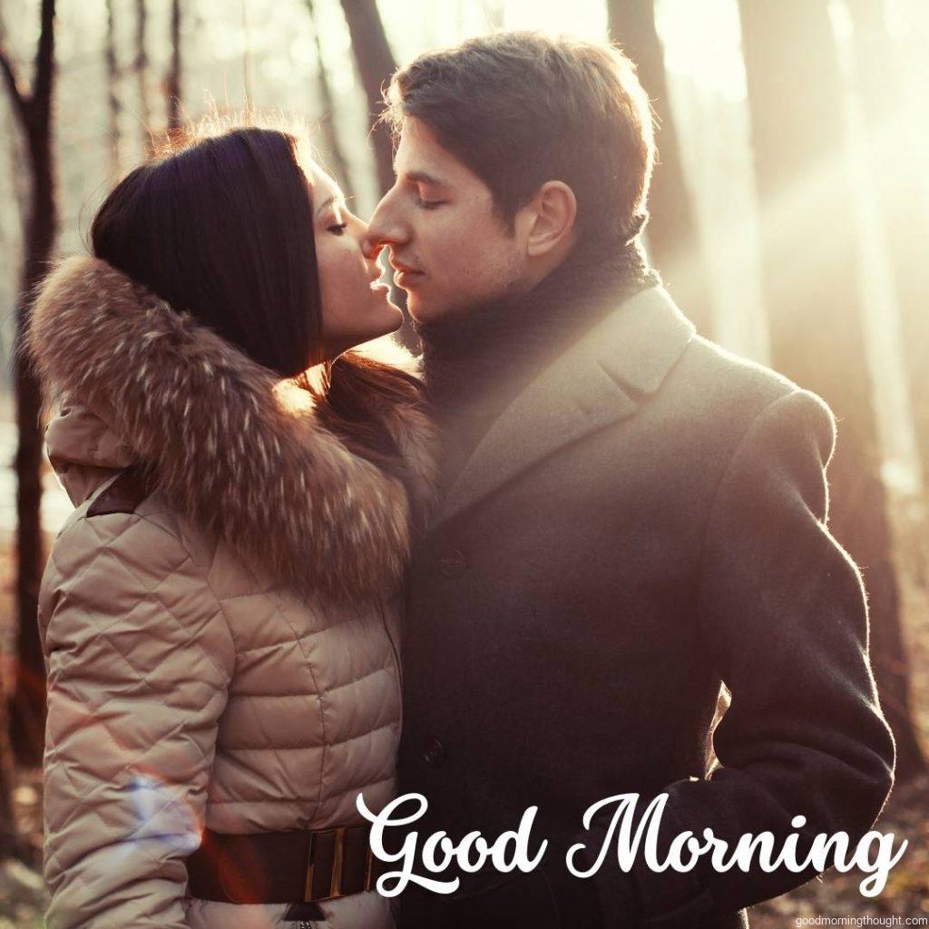 A young couple kissing in the forest, good morning image