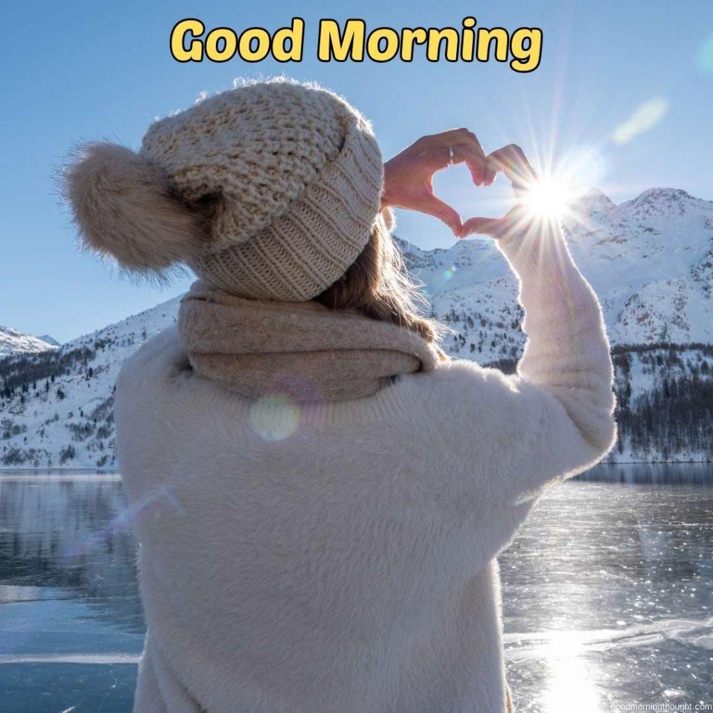 A young woman is ice skating on a frozen lake and making a heart with her hands. winter vacations, _Good morning_ text