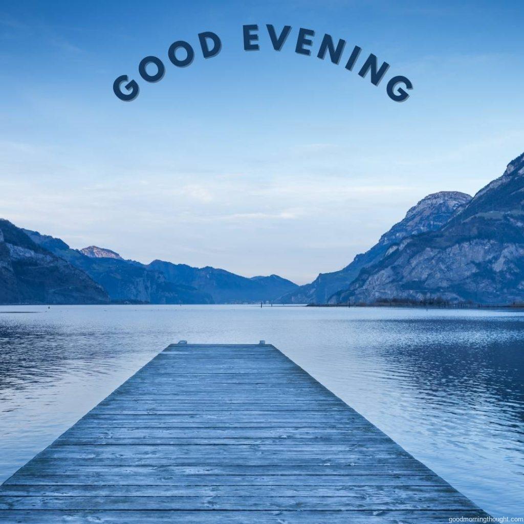 Background as an epic mountain landscape. Lake at sunset with a wooden pier, _Good Evening_ text