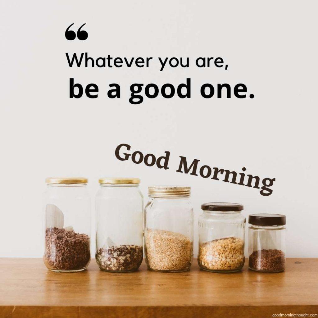 Close-up of glass jars with rice, split peas, and flaxseeds on an oak wooden shelf against a white wall—warm matte filter effect, Good morning text with an inspirational message