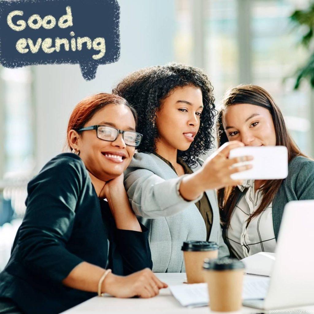 Cropped shot of young businesswomen taking a selfie while having a meeting in the convention centre in the evening, _good evening_ text