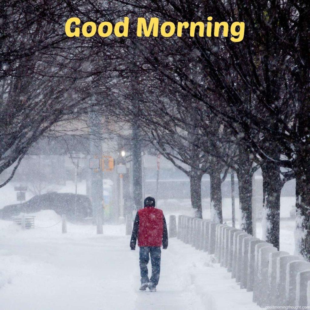 Daytime scene of a man walking during a snow storm, _Good morning_ text