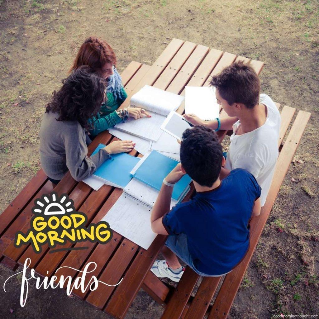 Four friends are studying outdoors with some books and a tablet. Good morning text