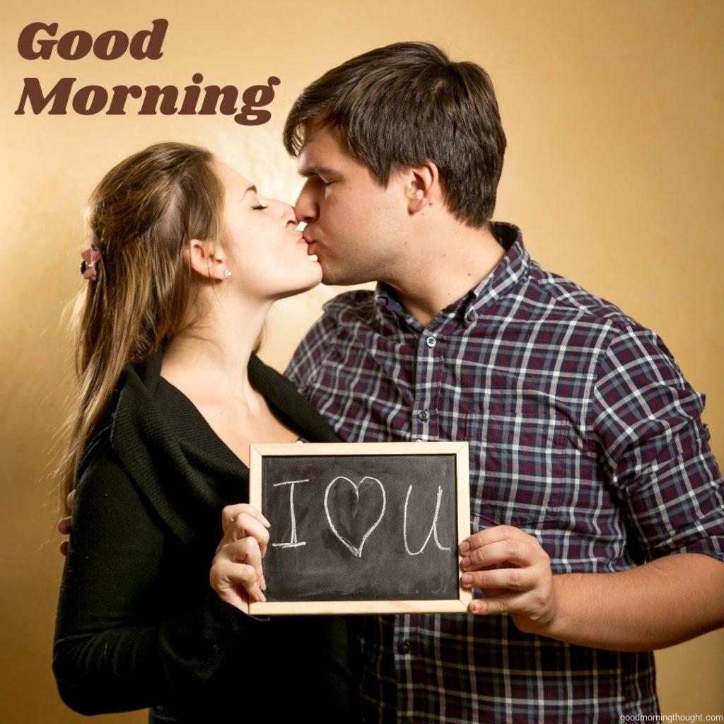 Happy couple kissing and holding a board with a declaration of love, Romantic Kiss Good Morning Image