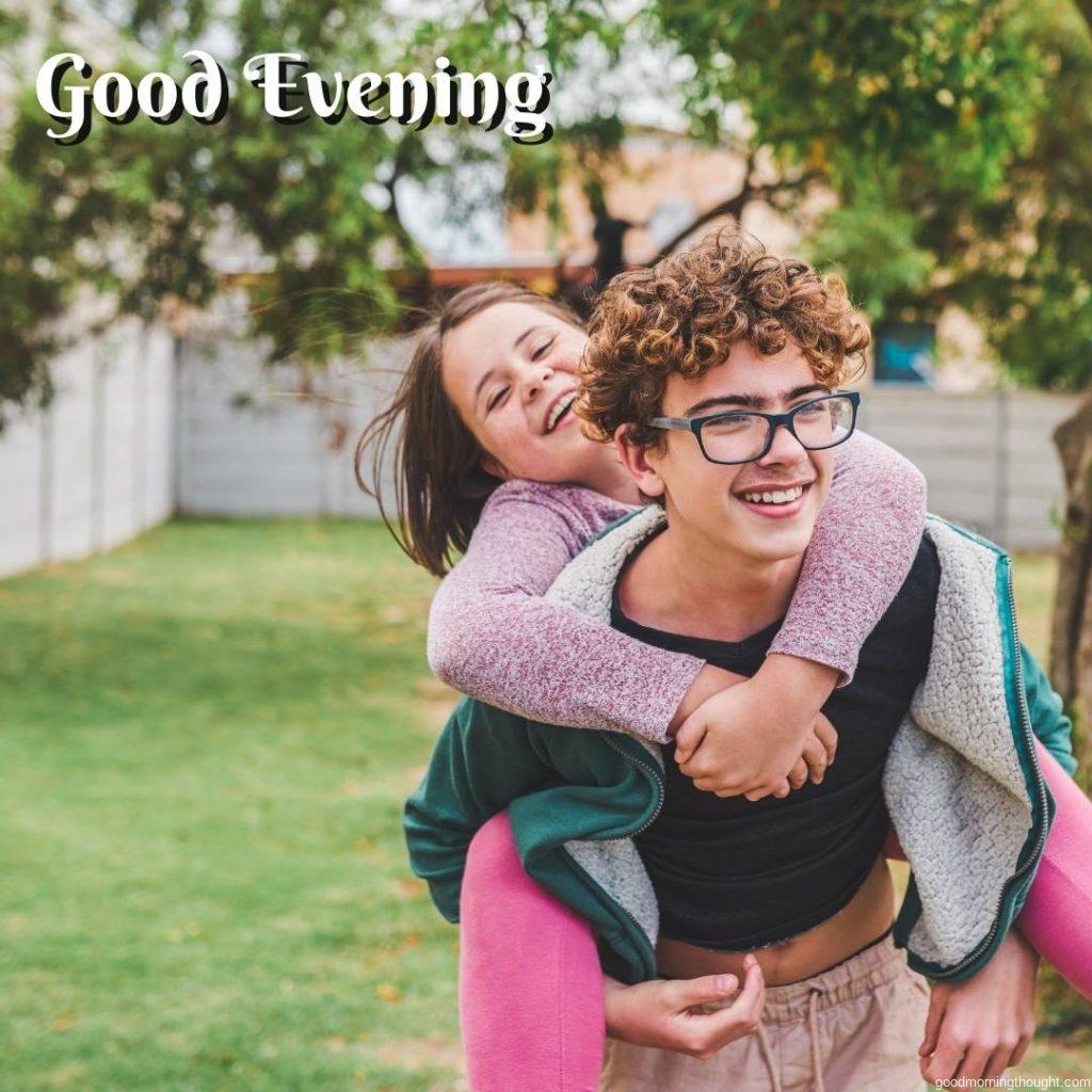 Shot of a young girl and her older brother playing together outside, _good evening_ text