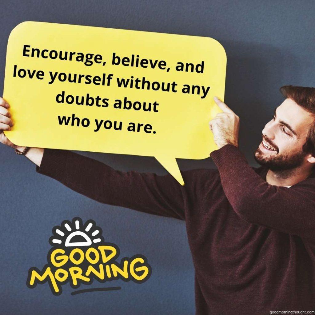 Studio shot of a young man holding a speech bubble against a grey background. Good morning text with an inspirational message