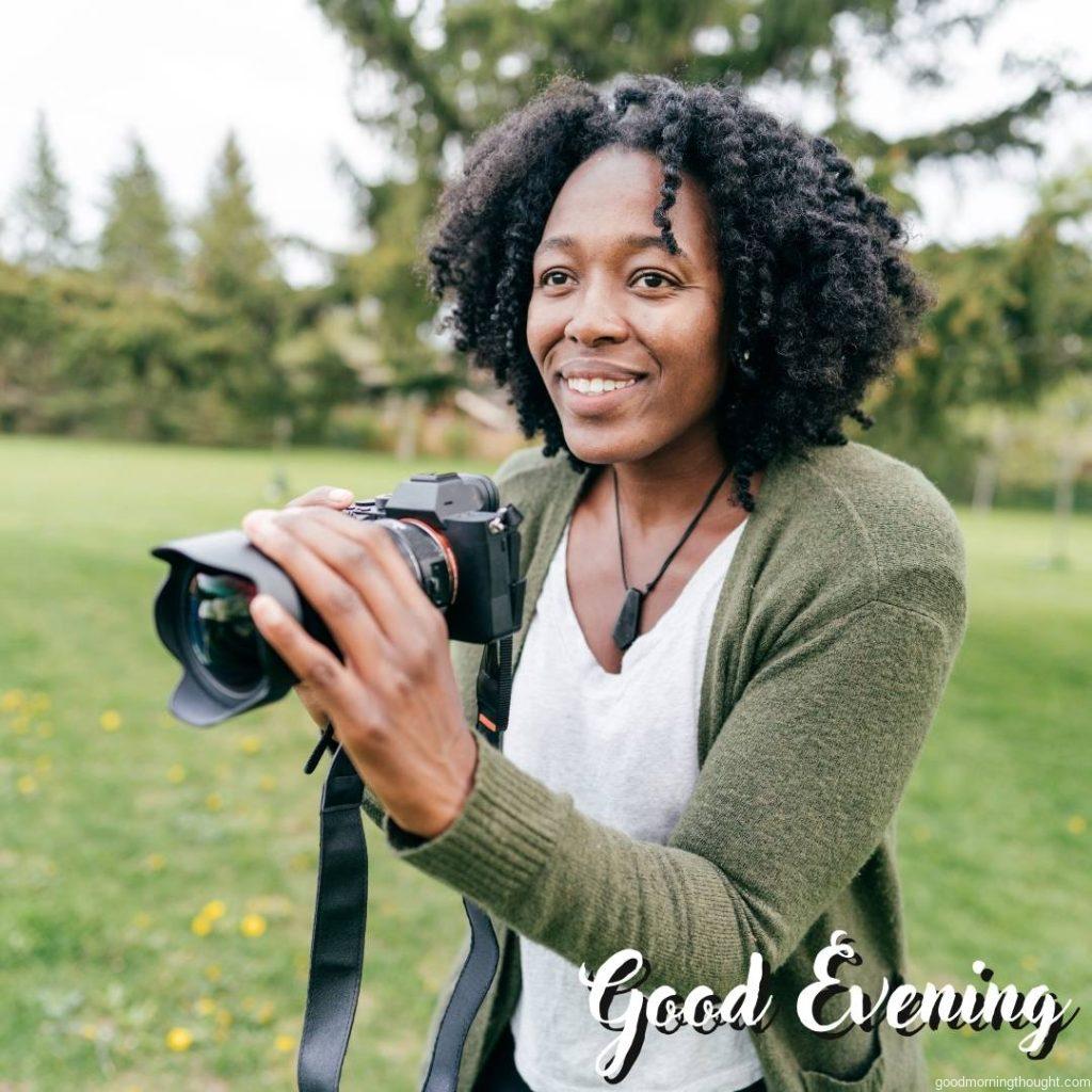 Woman snapping pictures outdoors, _Good Evening_ text