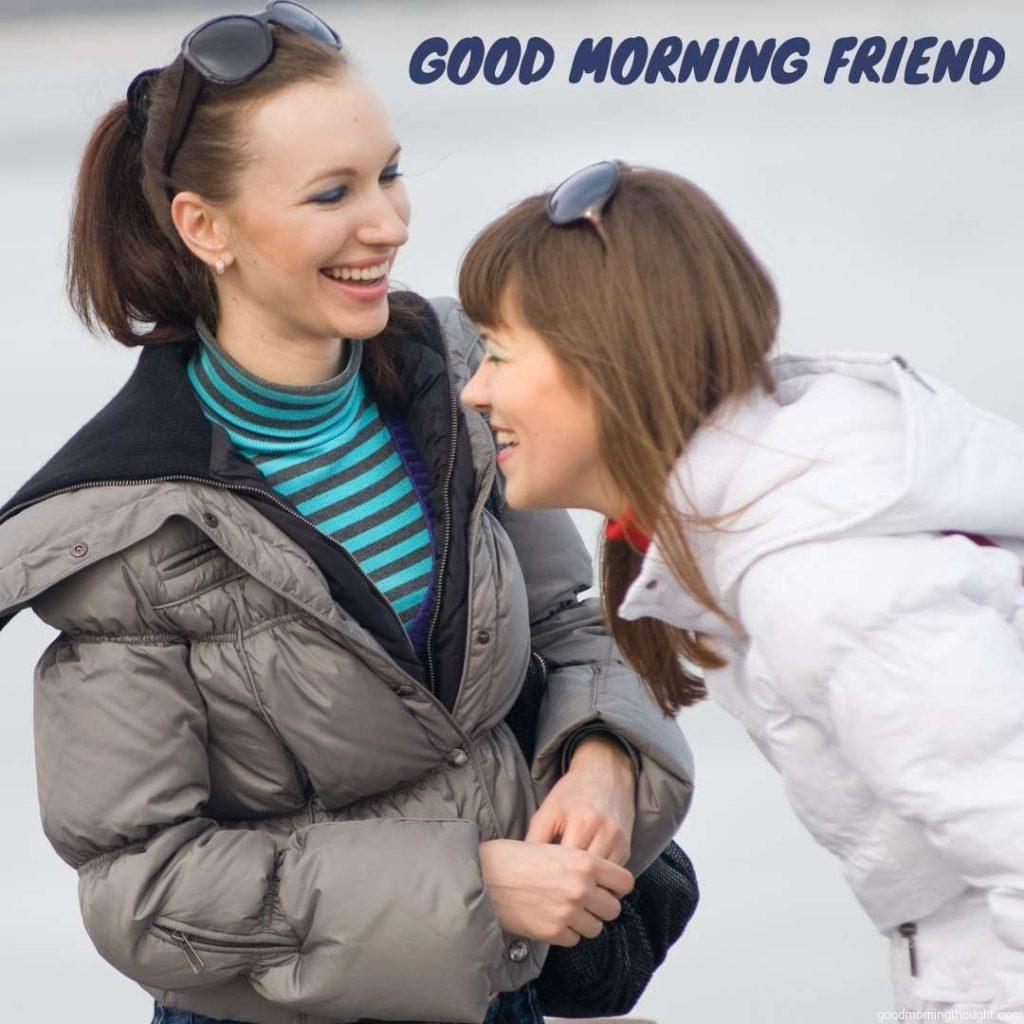 two girl friends talking and laughing outdoors. Good morning text