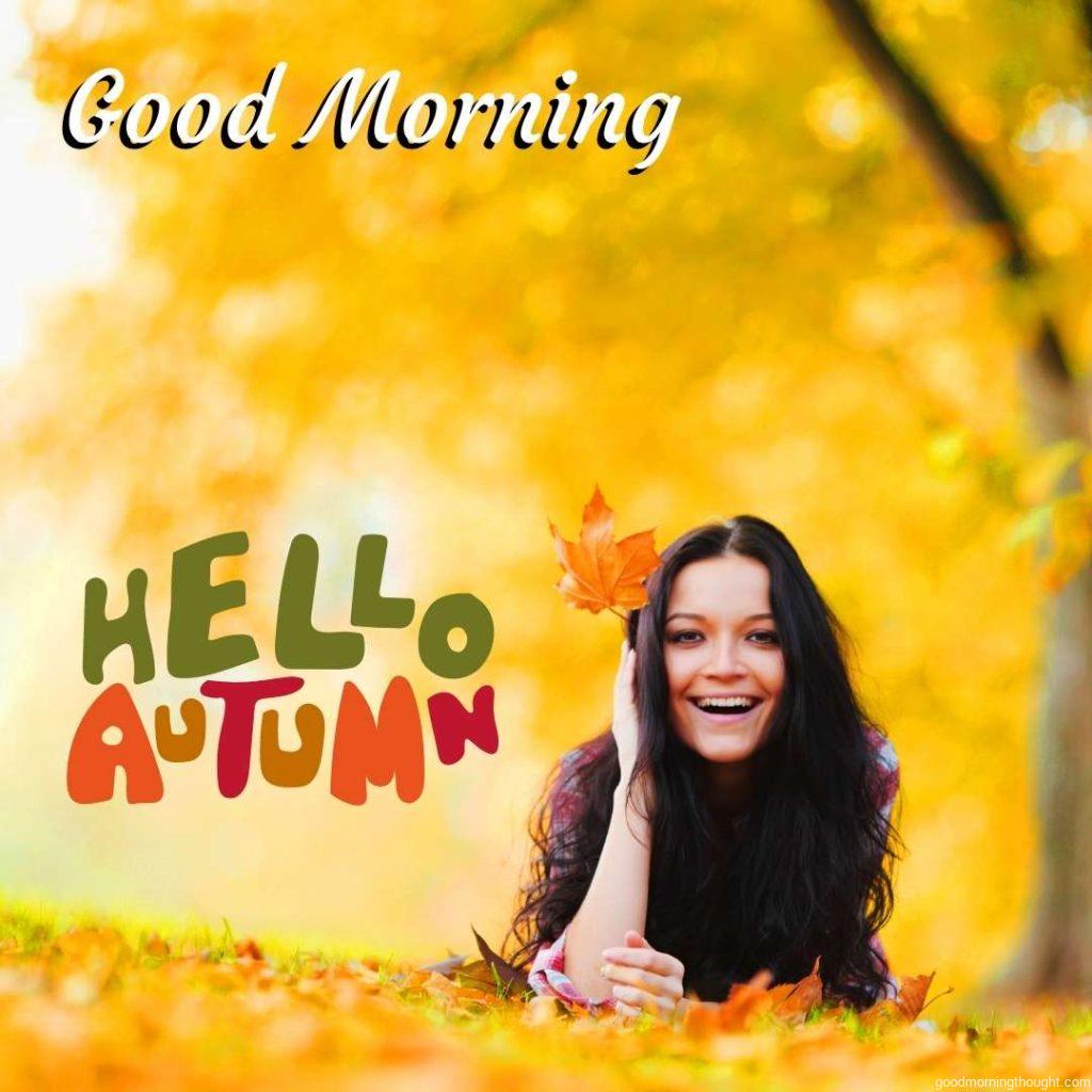 woman on leaves in an autumn park, good morning text, hello autumn