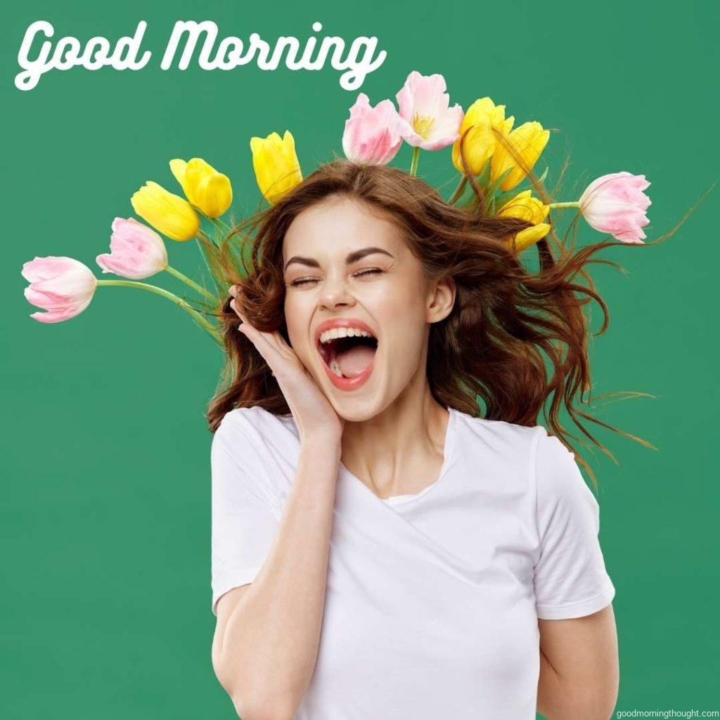 A woman in a beautiful dress with flowers gifts flowers on a light background in a Valentine's Day studio with _Good Morning_ text. Happy Good Morning Images