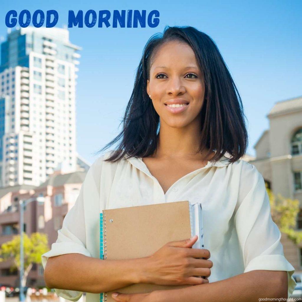 A young African American Student On Campus holds a notebook. African American Good Morning Images