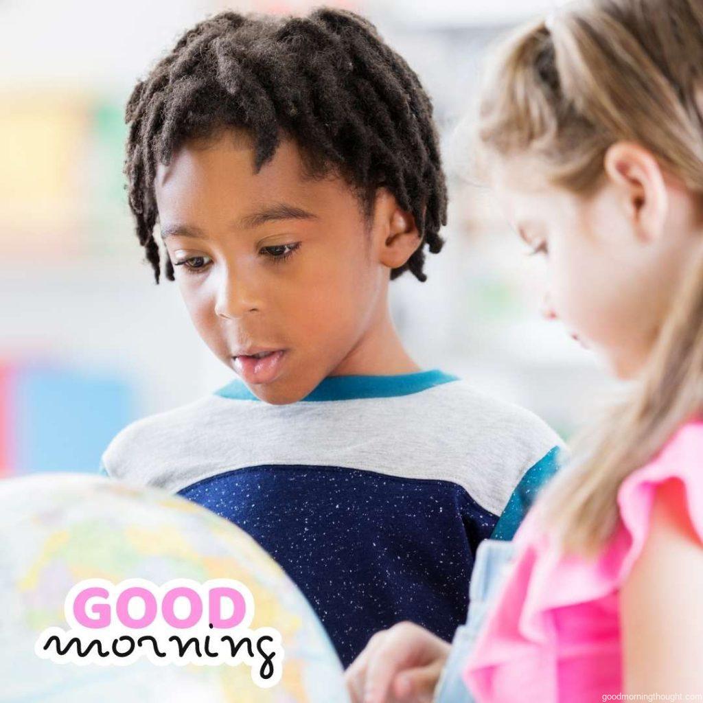 African American and Caucasian schoolchildren study the globe. Good Morning text