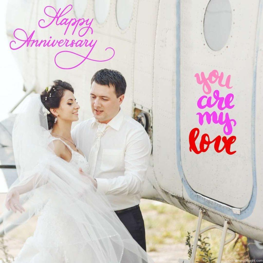 Bride and groom having fun next to an old aircraft. A wedding couple poses together against an aeroplane. Happy Wedding Anniversary Images