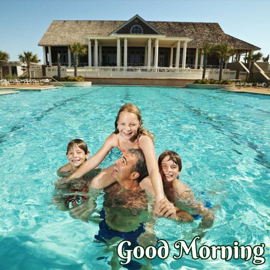 Caucasian family at pool with clubhouse in background, Happy Good Morning Images