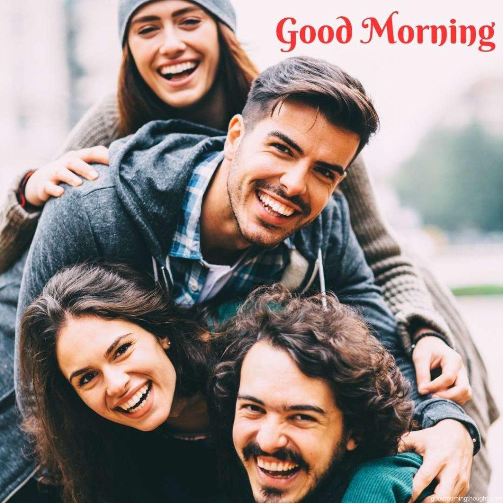 Four happy friends stand one over the other, posing for a photo. Word Good Morning