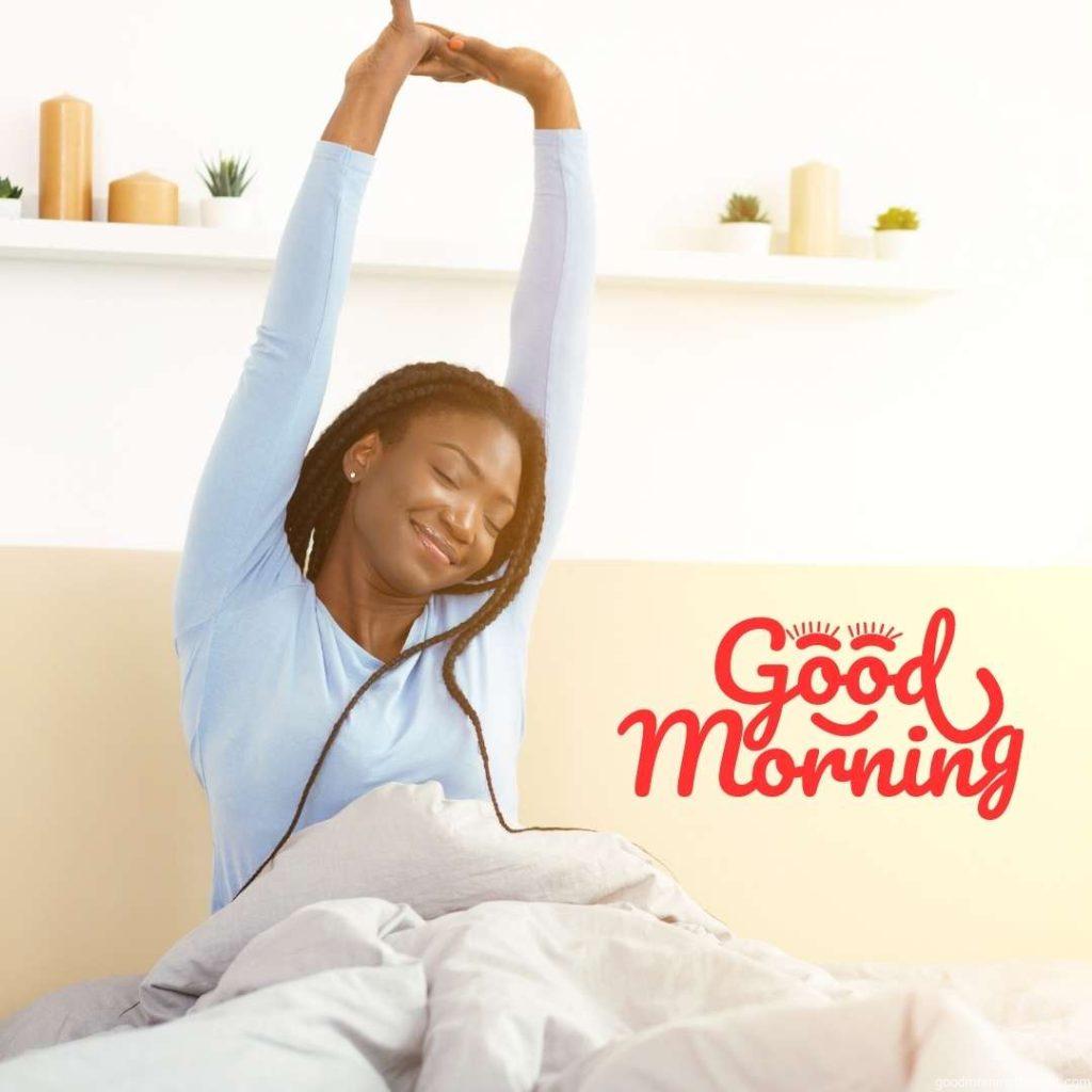 Good Morning. Happy Rested Black Girl Waking Up Stretching Arms Sitting In Bed In Bedroom _Good Morning_ text