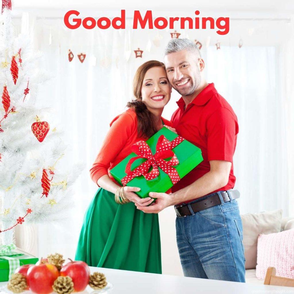 Portrait of a happy couple holding Christmas presents in their hands, embracing and laughing at the camera, _Good Morning_ text