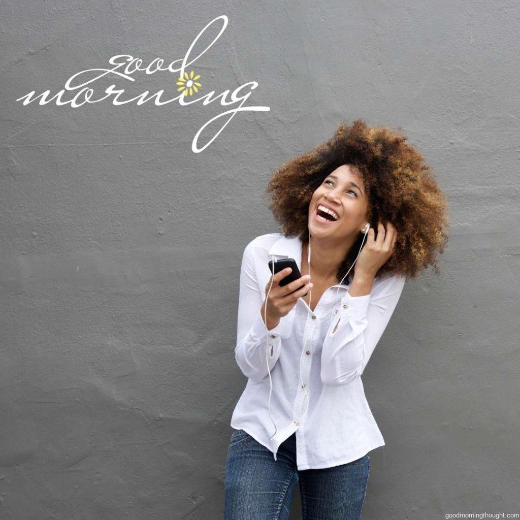 Portrait of a young African female laughing with earphones and a cell phone, African American Good Morning Images