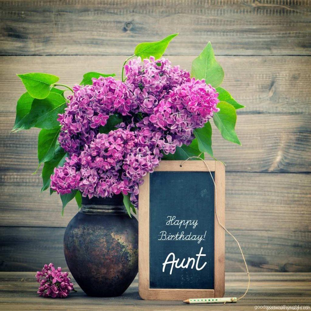 bouquet of lilac flowers on a wooden background. blackboard with sample text Happy Birthday Aunt